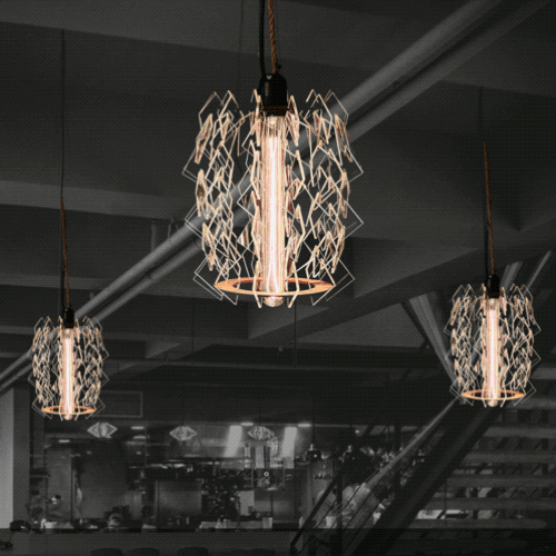 Three pendant lights with geometric wire cages around glowing filament bulbs hanging from a dark ceiling in a modern interior.