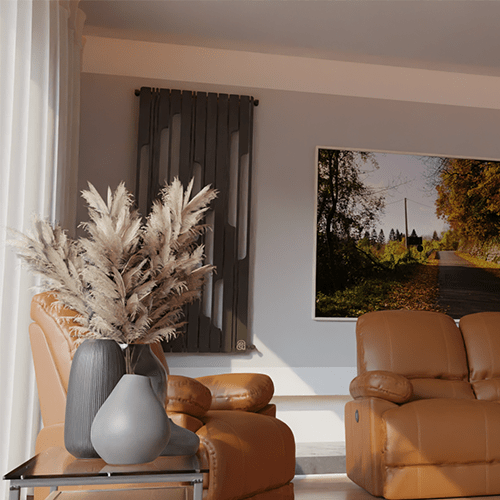 Cozy living room with tan leather chairs, a glass side table holding a gray vase with pampas grass, a dark radiator, and a framed countryside photo on a gray wall.