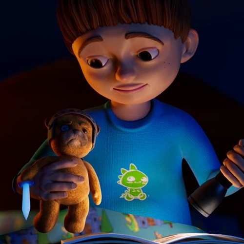 Young boy in a blue shirt reads a storybook at night, holding a teddy bear with a calm expression.