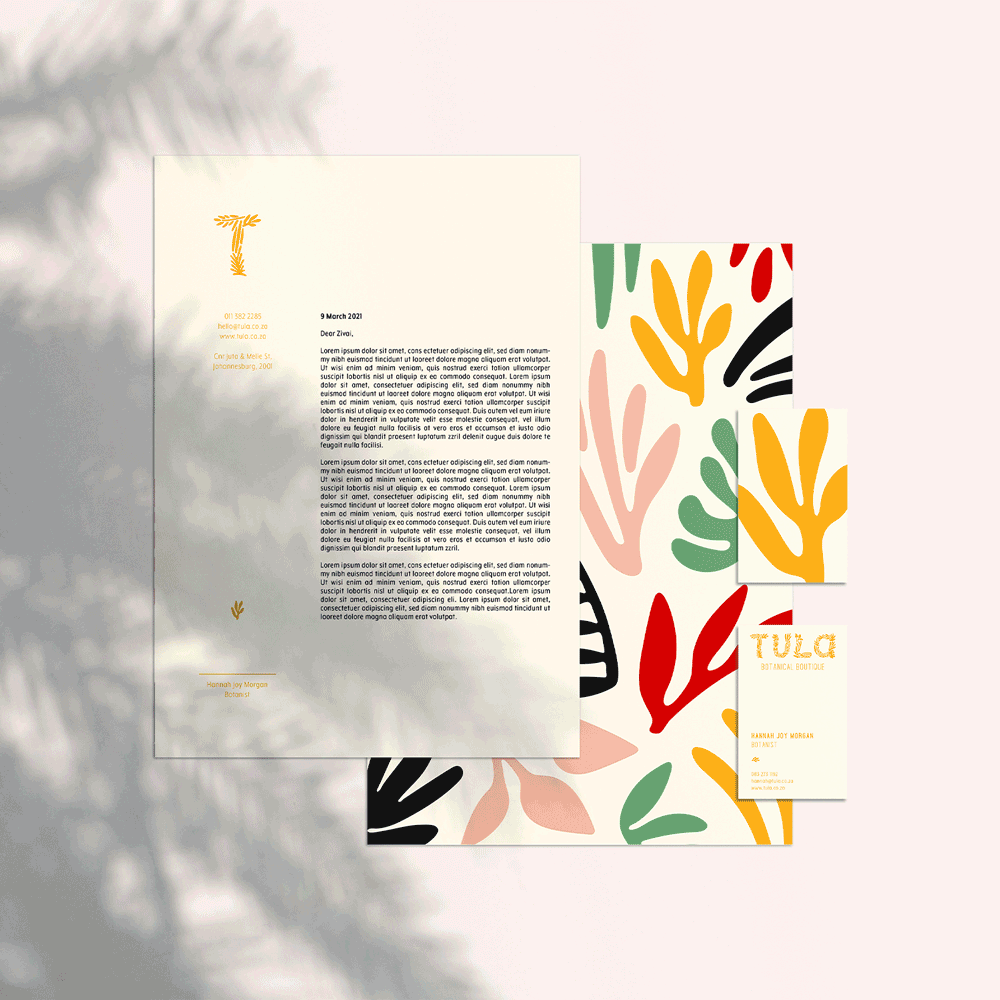 Branding stationery set with tropical leaf patterns: letterhead, colorful brochure, and business card on a pale background.