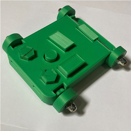 Green 3D-printed robot base with four wheels at the corners and various raised rectangular features on a square plate
