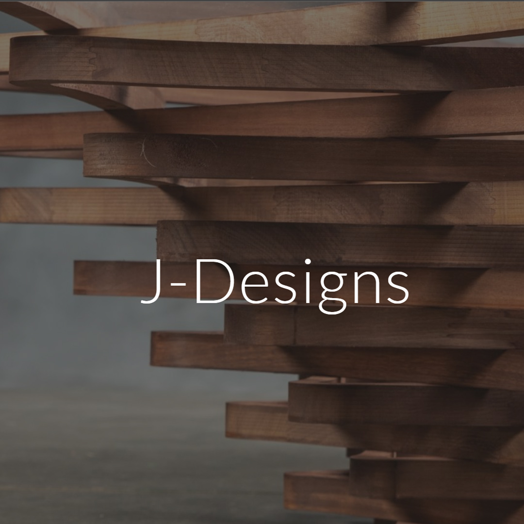 J-Designs logo over a stack of brown wooden planks.